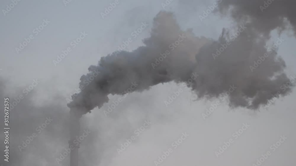 Dark hot smoke coming out of an industrial chimney of a chemical plant. Air pollution and global warming Dark hot smoke coming out of an industrial chimney of a chemical plant. Air pollution and global warming