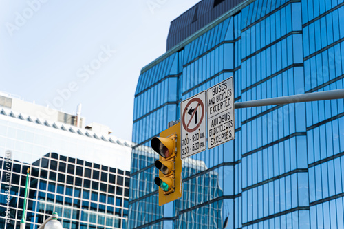Traffic light seen in front of glass high rise building in Ottawa, Ontario, Canada