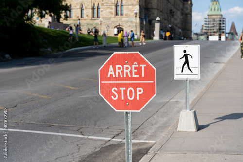 stop sign seen in front of government building in Ottawa, Ontario, Canada. Sign is in french and english