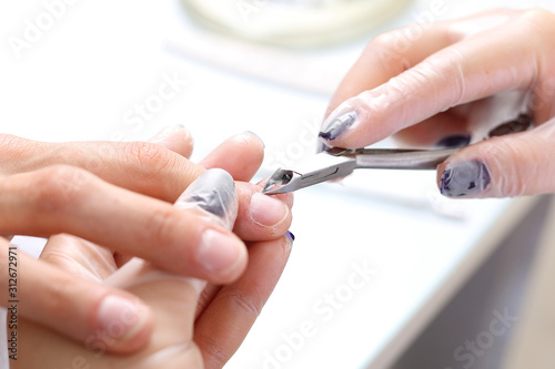 Manicure  cutting skins woman in a beauty salon.