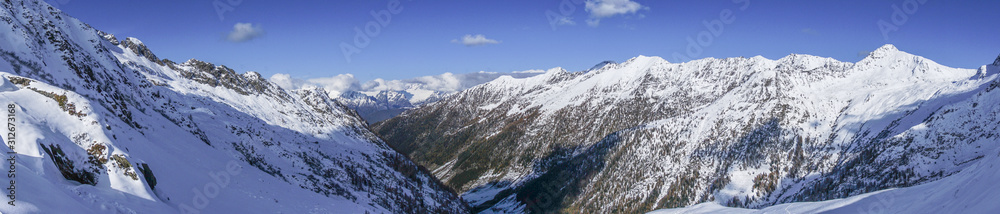 The snowy mountains, the nature and the landscape of the Valtellina after the first snowfall of the season in the Alps, near the town of Tartano, Italy - November 2019.