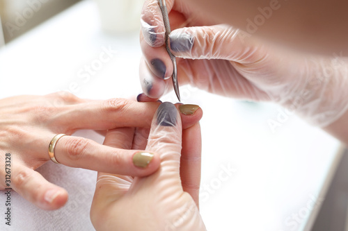 Cutting cuticles, manicure. Woman at the beauty salon