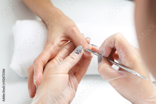 Manicure, cutting skins woman in a beauty salon.