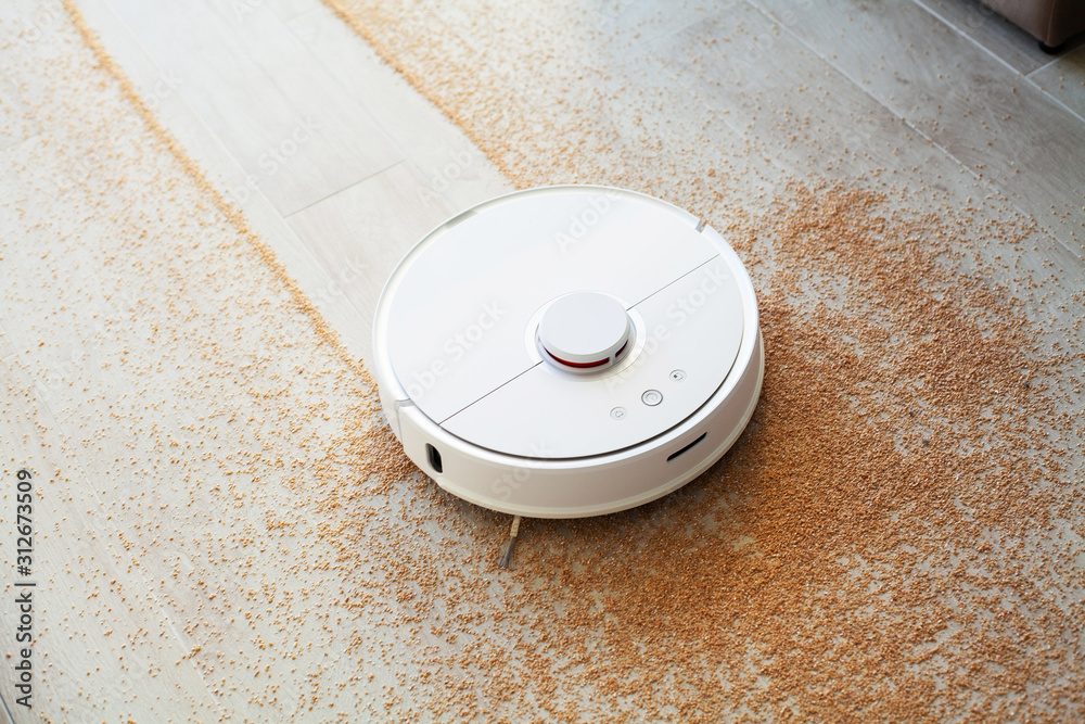 Smart House. Vacuum cleaner robot runs on wood floor in a living room - obrazy, fototapety, plakaty 