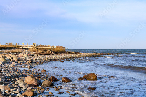 Fototapeta Naklejka Na Ścianę i Meble -  lonely stone beach in the sun with blue sea, Hohwacht, Germany