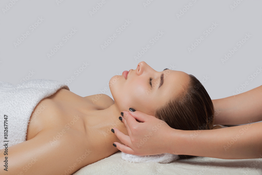 Masseur makes a relaxing massage on the ears, face, neck, shoulders and collarbones of a young beautiful woman in a spa. Cosmetology and massage concept. Masseur makes a relaxing massage on the ears, face, neck, shoulders and collarbones of a young beautiful woman in a spa. Cosmetology and massage concept.
