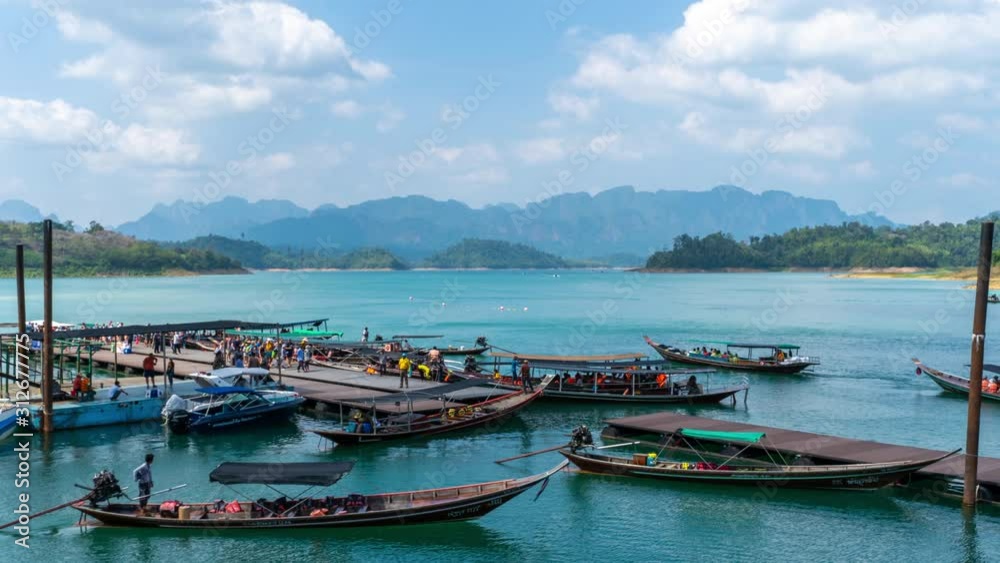 Tour boats busily take passengers on and off at the boat dock at Cheow Lan Dam or Ratchaprapa Dam in Surat Thani province, Thailand Tour boats busily take passengers on and off at the boat dock at Cheow Lan Dam or Ratchaprapa Dam in Surat Thani province, Thailand