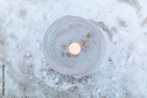 Ice lantern with candle burning inside