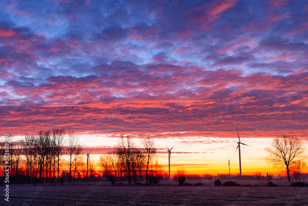 sunrise with windmills and colourfull clouds