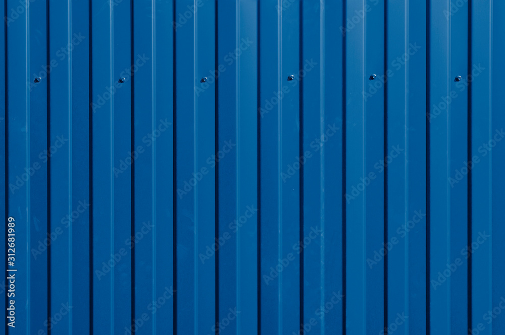 Iron fence with bright red ribs and cogs. Abstract background or texture in bright sunlight. Trendy color 2020 Iron fence with bright red ribs and cogs. Abstract background or texture in bright sunlight. Trendy color 2020