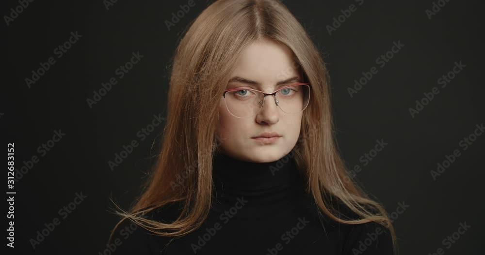 Determined young woman in black outfit and spectacles shaking head, negative reaction Determined young woman in black outfit and spectacles shaking head, negative reaction