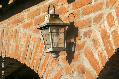 The warmth of a brick wall reflecting the sun light with an old metal lanternn photo