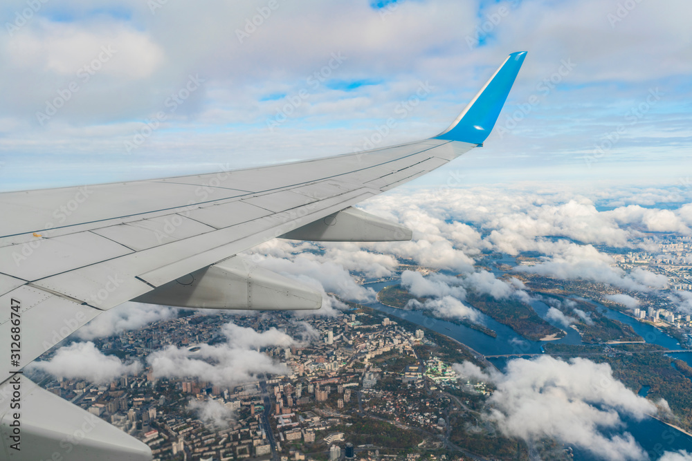 Obraz premium Looking over aircraft wing in flight under Kiev
