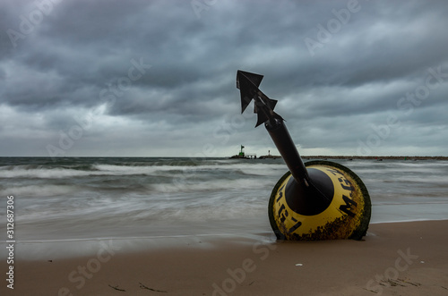 Żółta boja morska wyrzucona na brzeg, sztorm na morzu. 