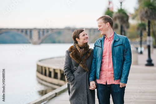 Couple holding hands and walking along the boardwalk in Georgetown, Washington DC