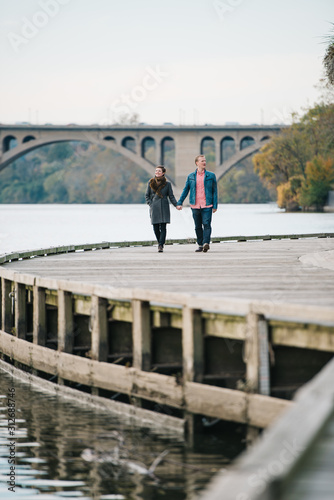 Couple holding hands and walking along the boardwalk in Georgetown, Washington DC