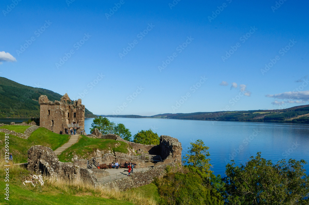 Ruins of Urquhart Castle on the shores of Loch Ness in the Scottish Highlands, with a beautiful blue sky in the summer. Drumnadrochit, Inverness, Scotland