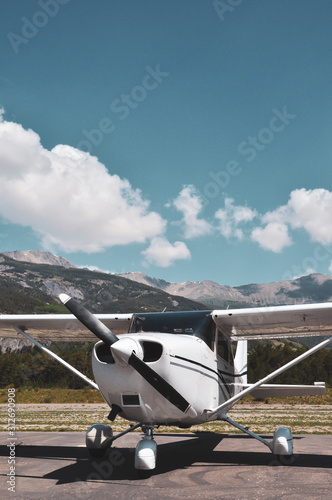 Single engine piston Cessna 172 parked at an airfield in the mountains photo