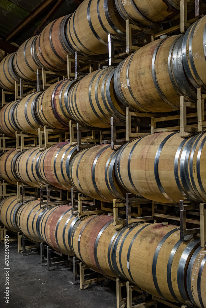 Rows of oak barrels stained with red wine stacked 4 high Rows of oak barrels stained with red wine stacked 4 high