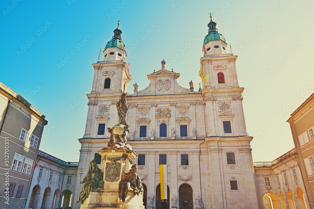 Famous Salzburg Cathedral, Salzburger Dom, at Domplatz in City Center of Salzburg Land, Austria on sunny day. Baroque roman catholic church and Marien Statue monument on square Beautiful architecture.