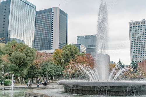 東京都千代田区日比谷にある都心にある公園の噴水と高層ビル群