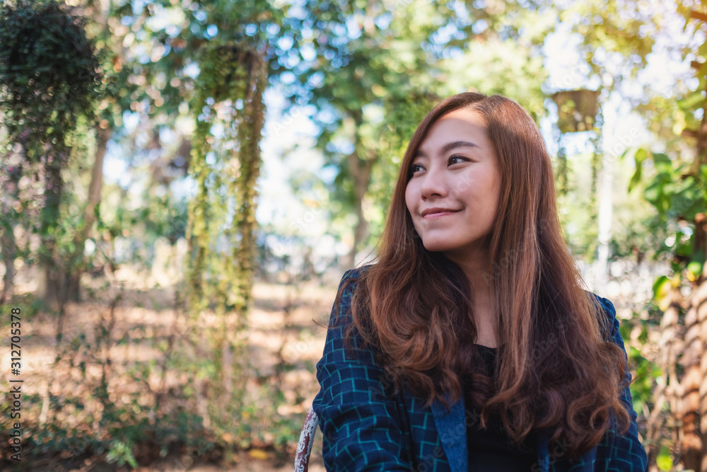 Portrait image of a beautiful asian woman sitting in the outdoors Portrait image of a beautiful asian woman sitting in the outdoors