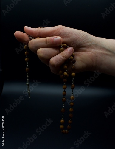 Hand holding Rosary beads