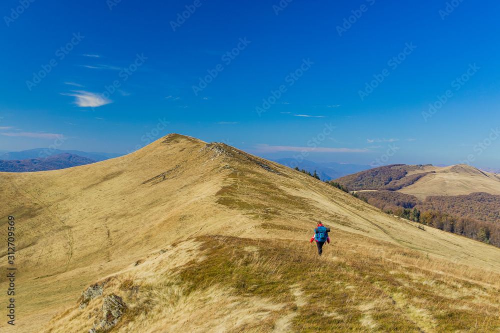 mountain range landscape hiking backpacker girl walking on touristic route life style concept landscape picture in spring time weather and blue sky background, copy space