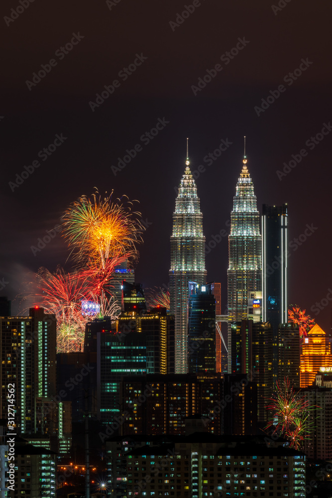 Fototapeta premium KUALA LUMPUR, MALAYSIA - 1ST JANUARY 2020; Fireworks explode near Malaysia's landmark Petronas Twin Towers during New Year celebrations in Kuala Lumpur.