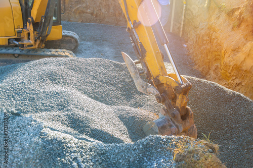 Moving gravel excavator in the construction works of a foundation of the house photo
