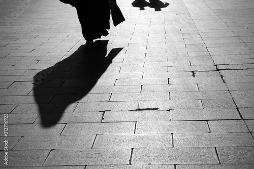 Canvas Print Shadow of a Muslem woman and two men walking on Eyup Sultan Boulevard Istanbul T