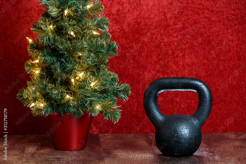 teater kontanter cafeteria Holiday fitness, black kettlebell, artificial Christmas tree with white  lights against a red background Stock-foto | Adobe Stock