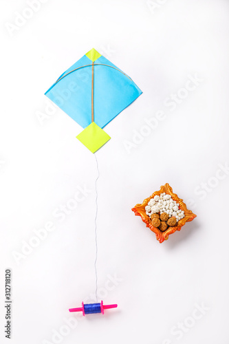 Celebrate Indian festival makar sankranti with colorfull kite,sesame seed ball,tilgul and chakri over white background  photo