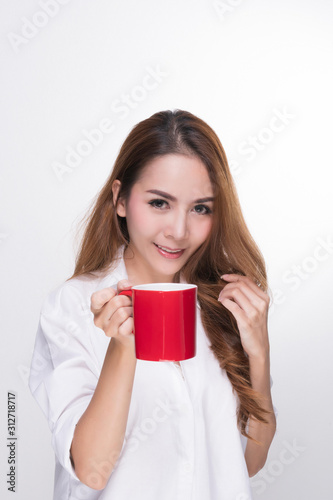 Asian woman portrait with perfect skin and wearing a white shirt in happiness holding red coffee cup isolated on white background.