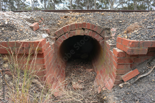 red brick culvert drain under railroad tracks photo