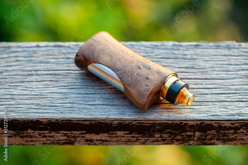 high end rebuildable dripping atomizer with stabilized natural walnut wood regulated box mods, vaping device, selective focus photo