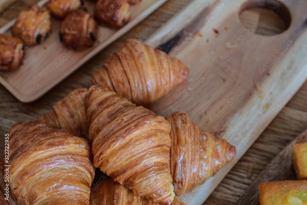 freshly baked croissants on wooden cutting board Warm Fresh Buttery Croissants and Rolls. French and American Croissants and Baked Pastries freshly baked croissants on wooden cutting board Warm Fresh Buttery Croissants and Rolls. French and American Croissants and Baked Pastries