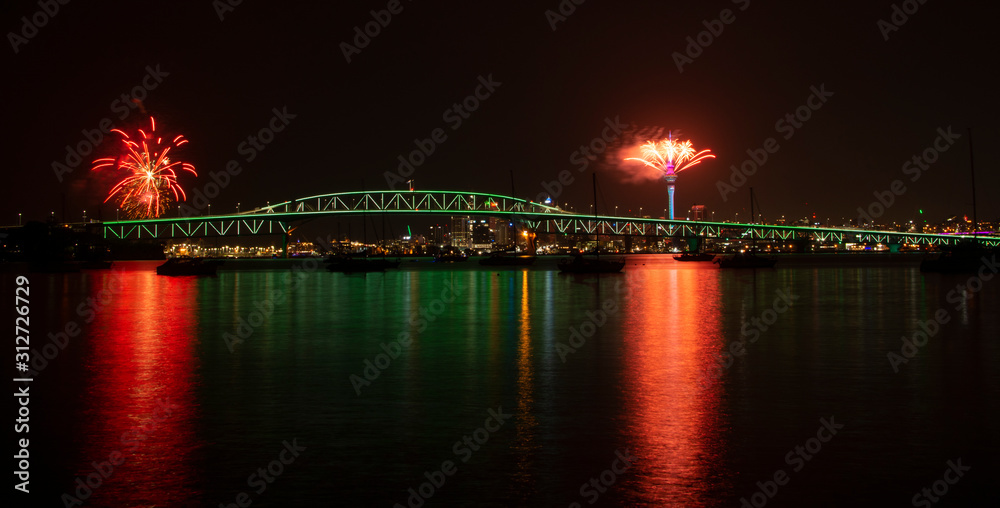 Auckland Sky Tower fireworks for New Year celebration with illuminated Harbor bridge