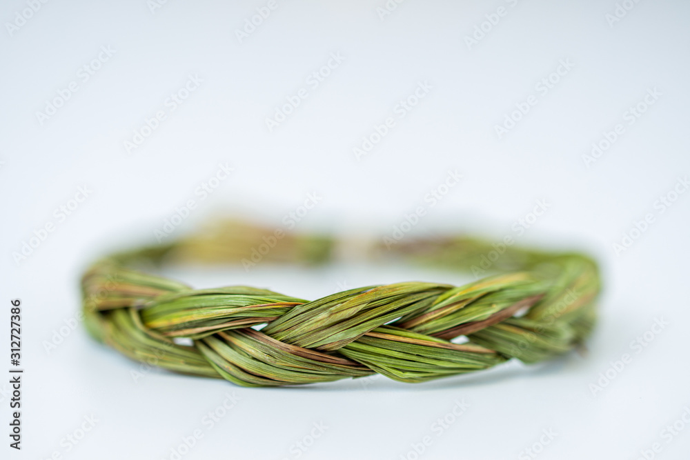 Close up of middle of green fresh sweetgrass braid tied in a circle isolated on white background Close up of middle of green fresh sweetgrass braid tied in a circle isolated on white background