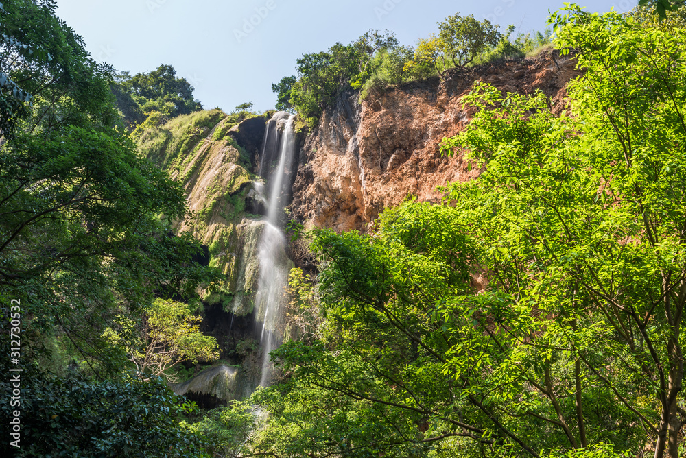 Waterfall flowing from high mountain cliff in Erawan national park. Erawan Waterfall 7 tier, Beautiful nature rock waterfall in tropical rainforest at Kanchanaburi province, Thailand