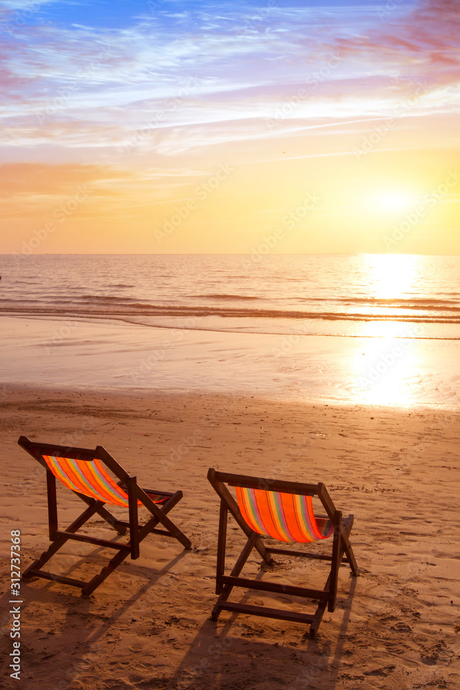 beach holidays vertical background, romantic getaway vacation on tropical sea coast, two deckchairs in hotel for couple