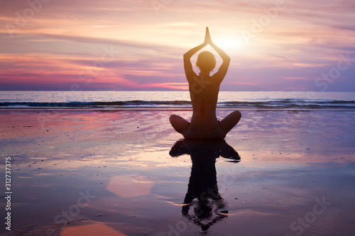 yoga meditation and mindfulness background, breathing exercise, silhouette of woman on the beach with copy space