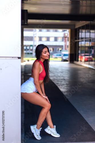 Young brunette woman standing in arch of building.