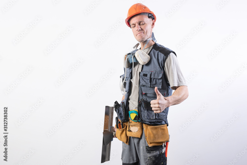 Builder with a spatula. And showing thumbs up. In work clothes and hard hat. On a light gray background. Builder with a spatula. And showing thumbs up. In work clothes and hard hat. On a light gray background.