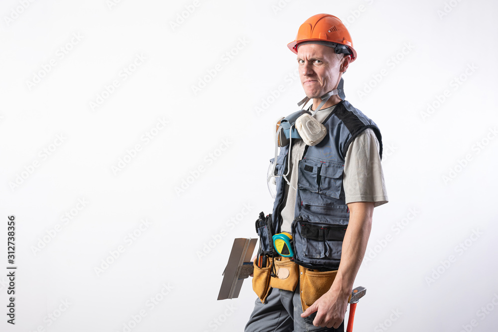 Builder with a spatula. With a funny face. In work clothes and hard hat. On a light gray background.