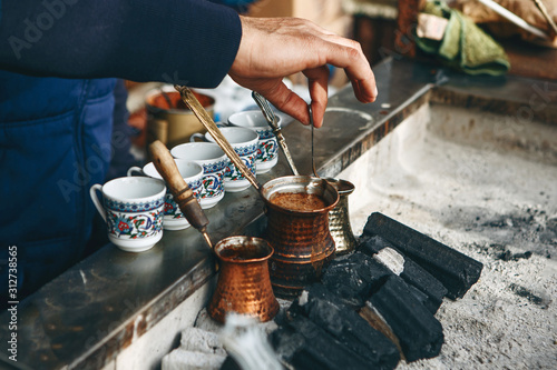 Cooking fresh aromatic traditional Turkish coffee on charcoal. Traditional turkish cuisine. photo