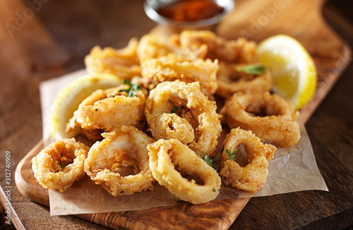 Fotografering fried calamari squid appetizer on wooden serving tray