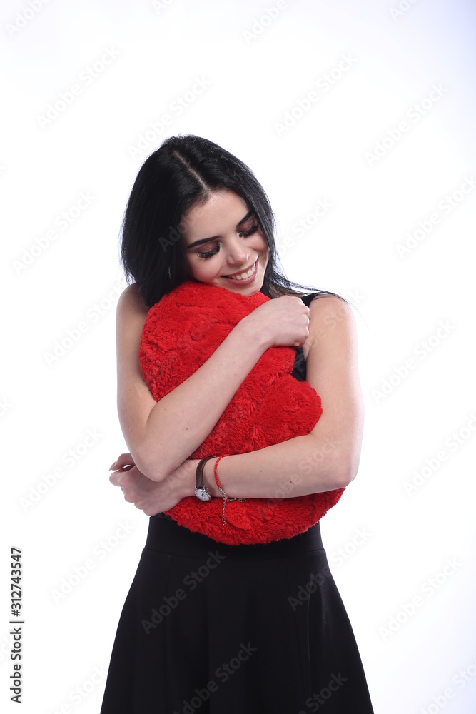 Beautiful young woman with heart shaped pillow in her hands on white background Beautiful young woman with heart shaped pillow in her hands on white background