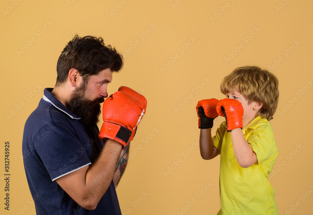 Little kid boxing with his coach. Dad and his son in boxing gloves. Child and instructor training in boxing ring. Happy father and son boxing together. Boy play fight with his father. Little kid boxing with his coach. Dad and his son in boxing gloves. Child and instructor training in boxing ring. Happy father and son boxing together. Boy play fight with his father.