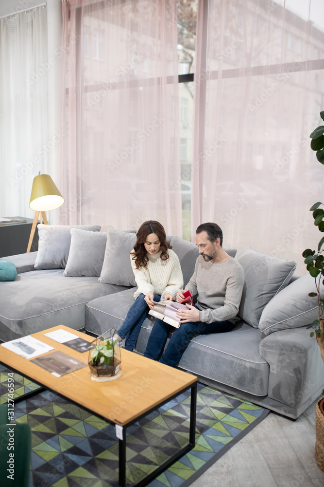 Man and woman in furniture salon looking involved Man and woman in furniture salon looking involved